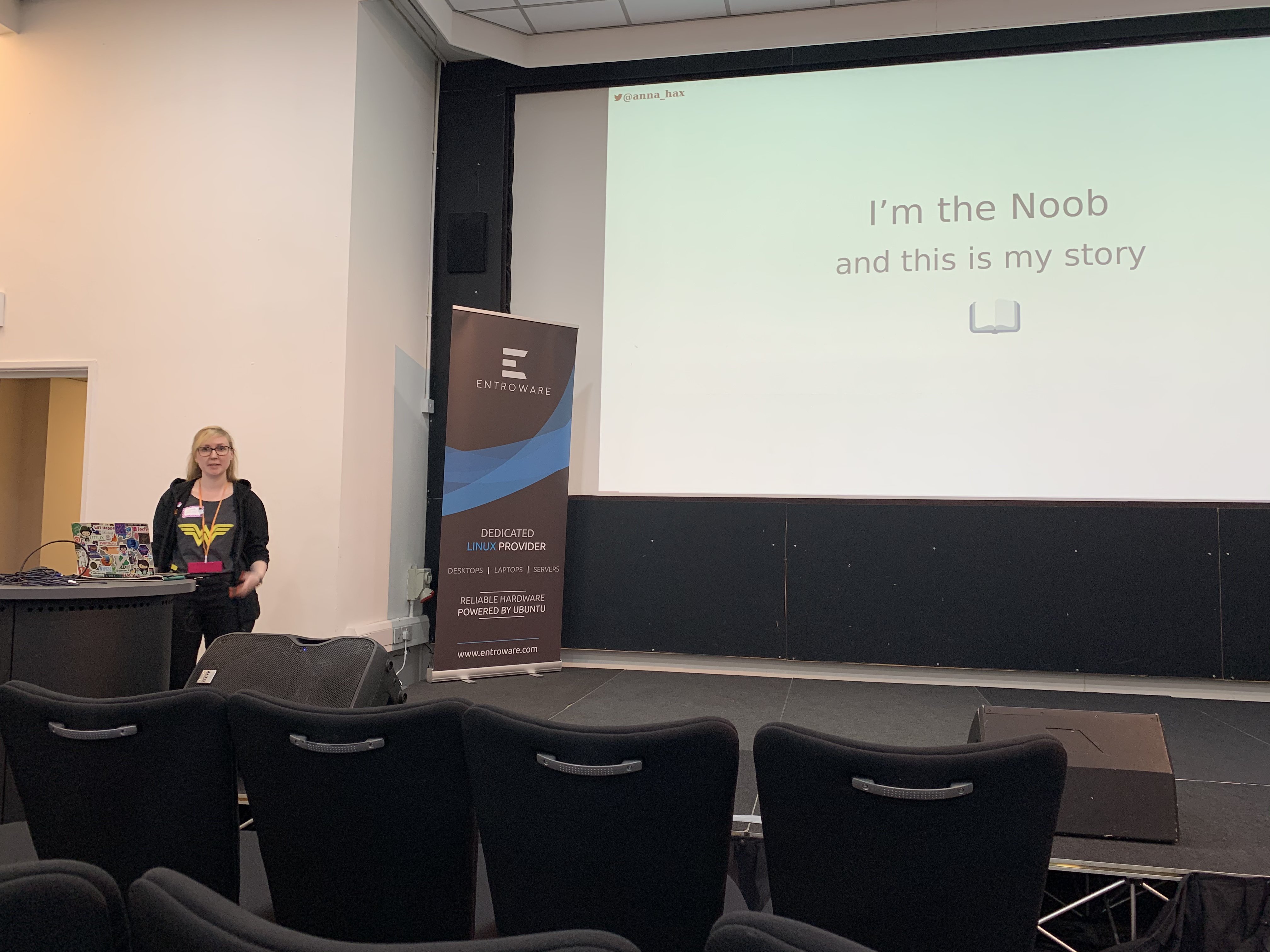 Photo of me at a lectern presenting the talk in front of slide saying 'I'm the noob and this is my story'.